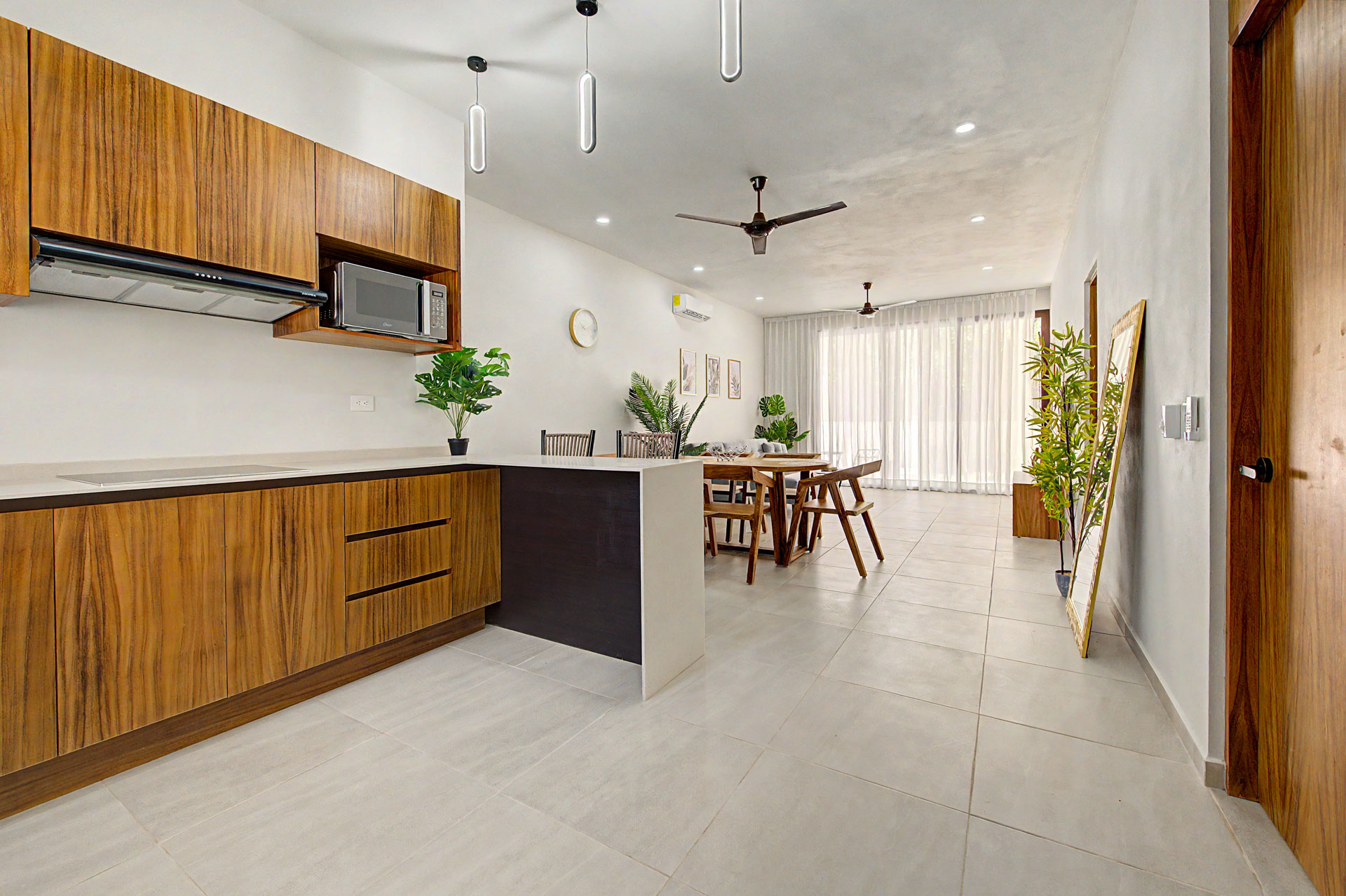Open-plan wood kitchen and dining area inside a Tulum Gardens townhouse